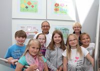 Francesco Fazio (Allgemeinmediziner) und Ingrid Dlugai (Leiterin der Kunst-AG) freuen sich gemeinsam mit den Kindern der Georgschule über die willkommenen Hingucker im RIGA-RING-Ärztehaus.